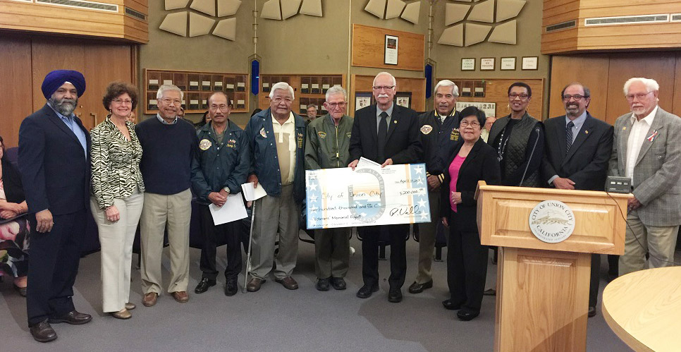 Supervisor Valle and group of veterans posing with 200 thousand dollar check for memorial funding